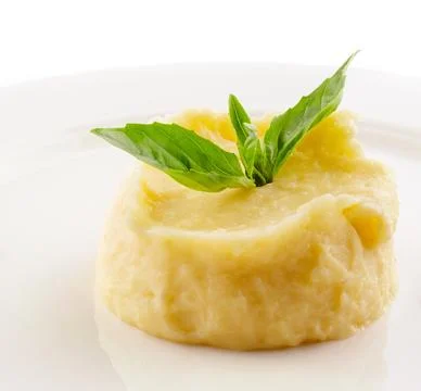 Mashed potatoes and basil on white plate Stock Photos
