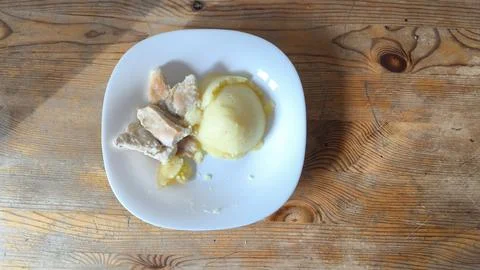 Mashed potatoes and roasted meat served on white plate on wooden table Foto stock