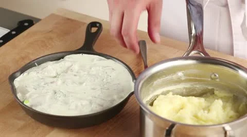 Mashed potatoes being placed on fish pie ingredients 스톡 동영상 24671543