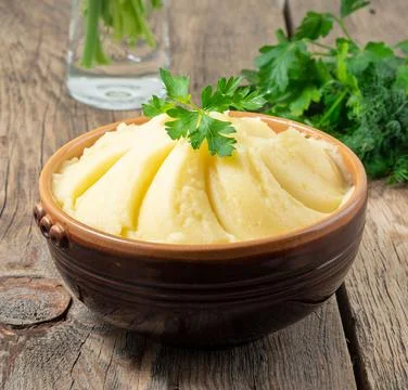 Mashed potatoes, boiled puree in brown bowl on dark wooden rustic background Stock Photos