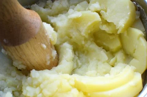 	 Mashed potatoes cooking, making process with a wooden mesher in a sucepan Stock Photos