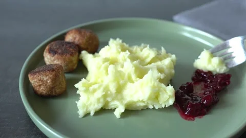 Mashed potatoes with meatballs and lingonberry jam. An unrecognizable person. Stock Footage 341550700