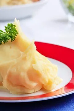 Mashed potatoes with parsley garnish on plate Stock Photos