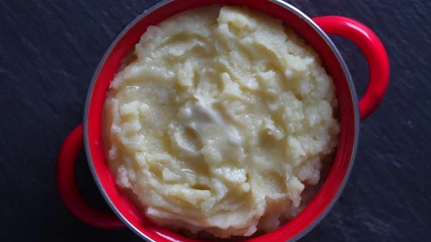 Mashed potatoes in a red saucepan rotate , close up Stock Footage 182013887