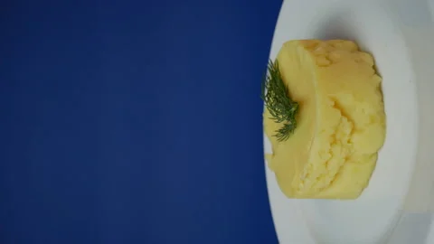 Mashed potatoes in a rotation plate on a blue background. Ready serving dish Stock Footage 163608301