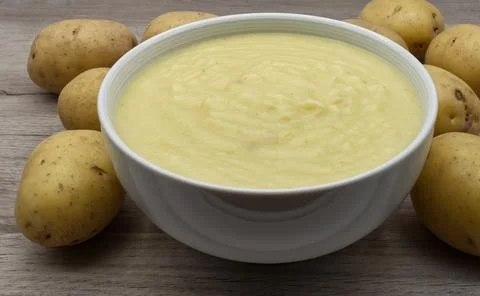 Mashed potatoes in small bowl decorated with raw potatoes Stock Photos