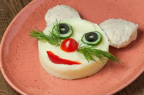 Mashed potatoes with steamed cutlet and greens in a plate in the form of a fa Stock-Fotos