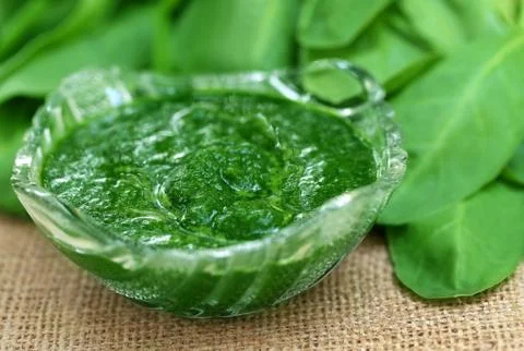 Mashed spinach in a bowl on jute Stock Photos