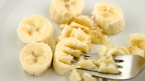 Mashing banana pieces into paste with fork Stock Footage 46961259