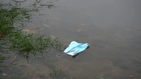 Mask floats slowly down the river. environmental pollution concept Stock Footage 154956170