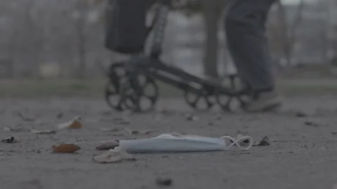 Mask laying on the ground, elderly walking - Coronavirus Covid-19 Epidemic | LOG Stock Footage 165658692