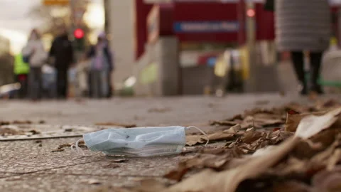 Mask laying on ground, get trampled, city - Coronavirus Covid-19 Epidemic Stock Footage 165683865