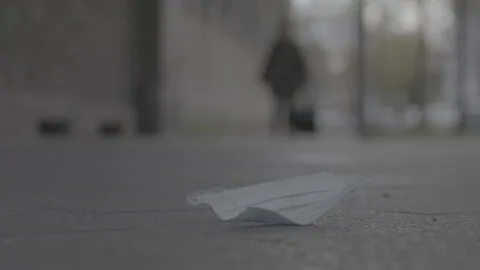 Mask laying on the ground, moves in wind - Coronavirus Covid-19 Epidemic | LOG Stock Footage 166033073