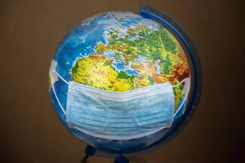 Mask put on the globe close-up Russian language on the country name . The con Stock Photos
