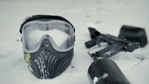Mask, weapon (machine) for paintball. close-up, which puddle in snow in winter Stock Footage 231808601