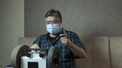 Masked asian man sharpens knives on a grinder Stock-Footage 143672225