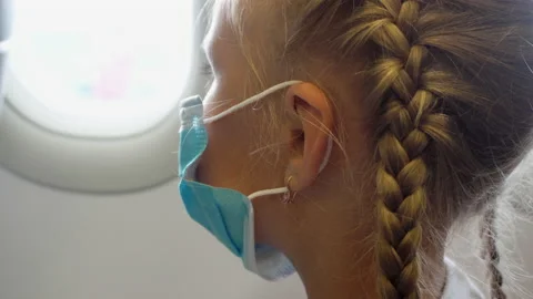 Masked child at the plane window Stock Footage 138083949