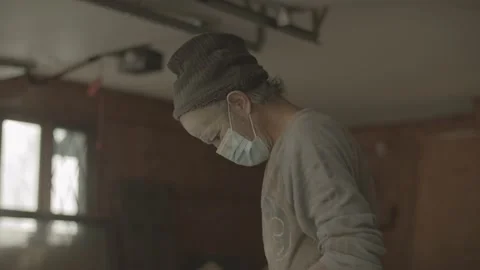 Masked construction worker prepares to cut stone in a garage Stock Footage 146196996