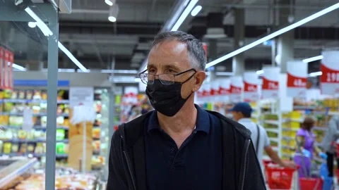 Masked elderly man walks in the store 스톡 동영상 133781550