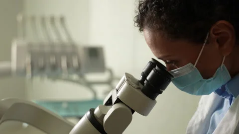 Masked female dentist using microscope during work Stock-Footage 156872331
