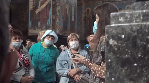 A masked guide leads a guided tour of the cathedral Stock Footage 158991371
