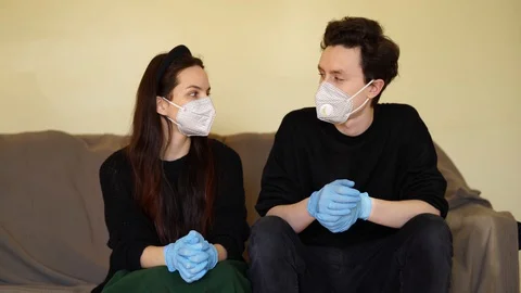 Masked guy and rubber gloves fooling around on couch 스톡 동영상 129670741