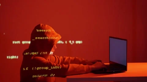 Masked hacker coding in dark room with police flashing lights and source code Stock Footage 307020277