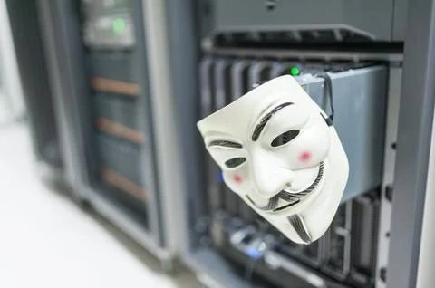 Masked Hacker in Computer Server room Concept Stock Photos