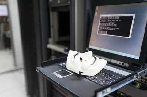 Masked Hacker in Computer Server room Concept Stock Photos