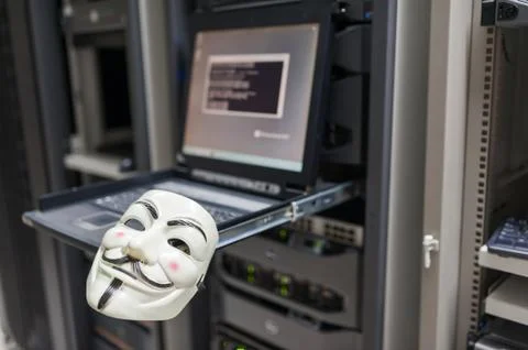 Masked Hacker in Computer Server room Concept Stock Photos