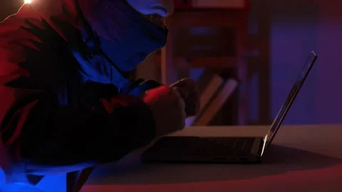 Masked hacker is glad happy that he managed to crack the code Stock Footage 237644703