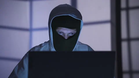 Masked hacker working from laptop to find security password. 스톡 동영상 227565358