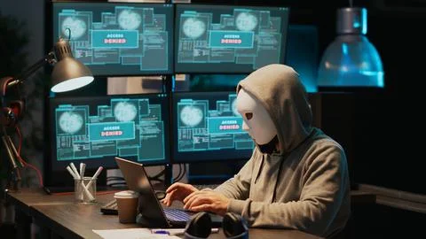 Masked hacking thief stealing information from database server Stock Photos