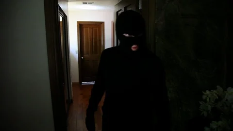 Masked Intruder creeps down hallway Stock Footage