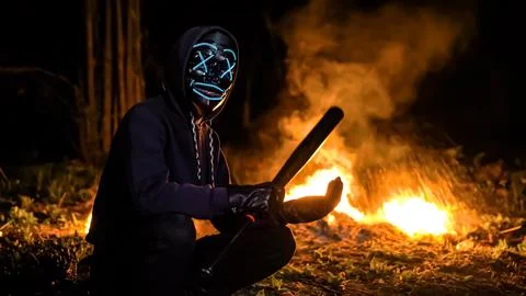 Masked man with a baseball bat on the background of fire. Fire Blast back Stock Photos