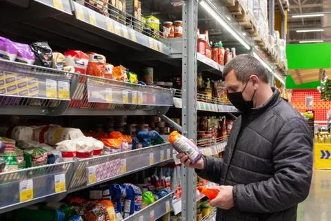 A masked man buys food at the Lenta chain store during the covid19 pandemic. Stock Photos