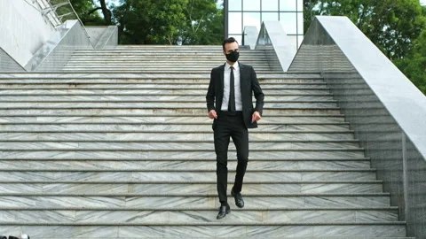 A masked man, dancing, goes down the stairs to an electric scooter 스톡 동영상 136893966