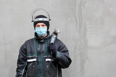 Masked man with grinder in hands Foto stock