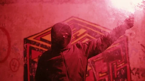 Masked man lights fire Stock Footage 129906363