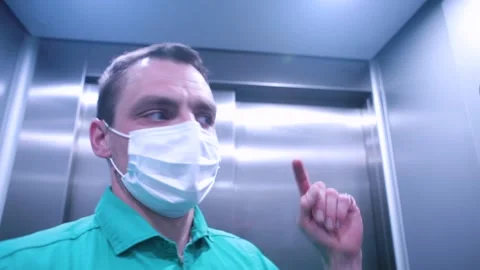A masked man makes a video call from the elevator. Stock-Footage 137021389