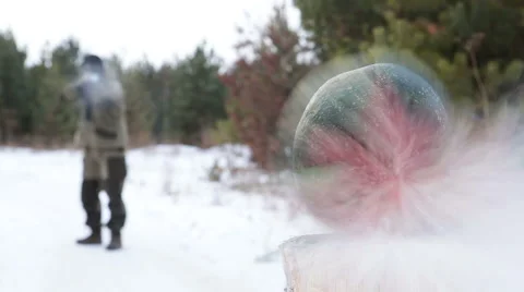 Masked man shoots into the watermelon Stock Footage 44786288