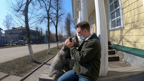 A masked man strokes a dog Stock Footage 128515501
