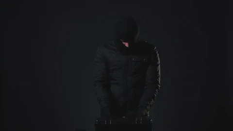A masked man takes a gun in hand. Terrorism concept Stock Footage