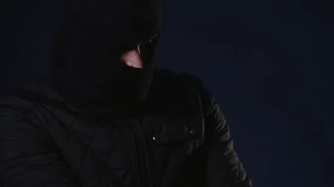 A masked man takes a gun in hand. Terrorism concept Stock Footage