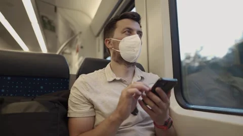 Masked man using a smartphone inside a German city train. A modern reflection of Video stock 310502478