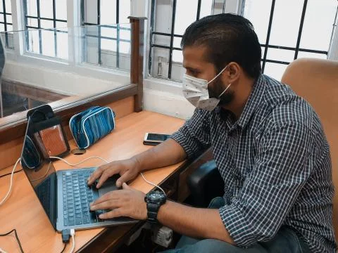 Masked man working on Computer Stock Photos
