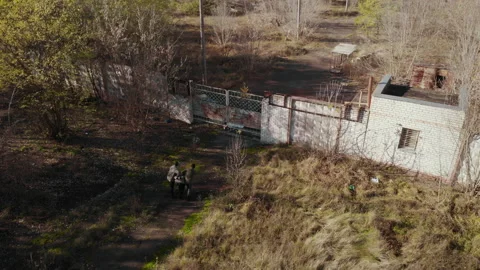Masked men lead a captive to the gates of an abandoned factory Stock Footage 219407540