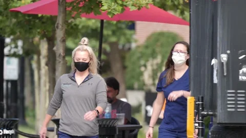 MASKED NURSES WALKING ON SIDEWALK, OVER-CRANKED FTG. Stock Footage 137432271