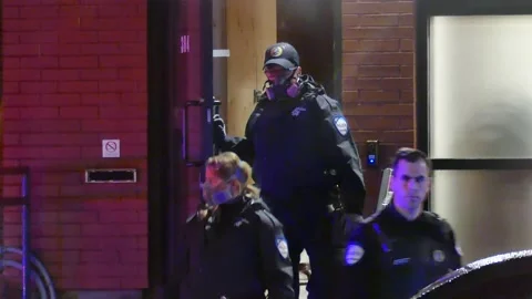Masked officers getting out of commerical building Stock Footage 138651685