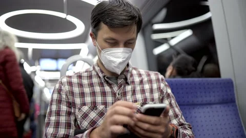 Masked passenger on subway in Munich uses 5G Internet on his smartphone. Self Stock Footage 219954562